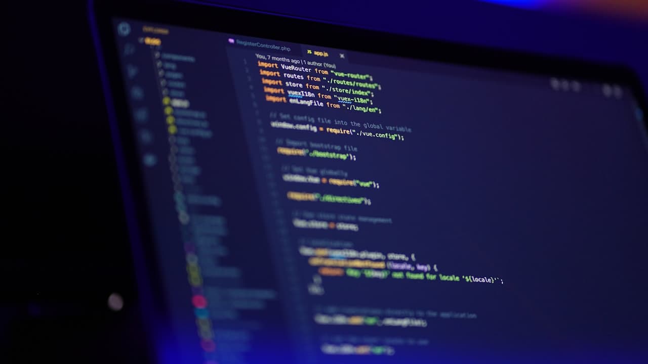 A laptop screen displaying colourful source code