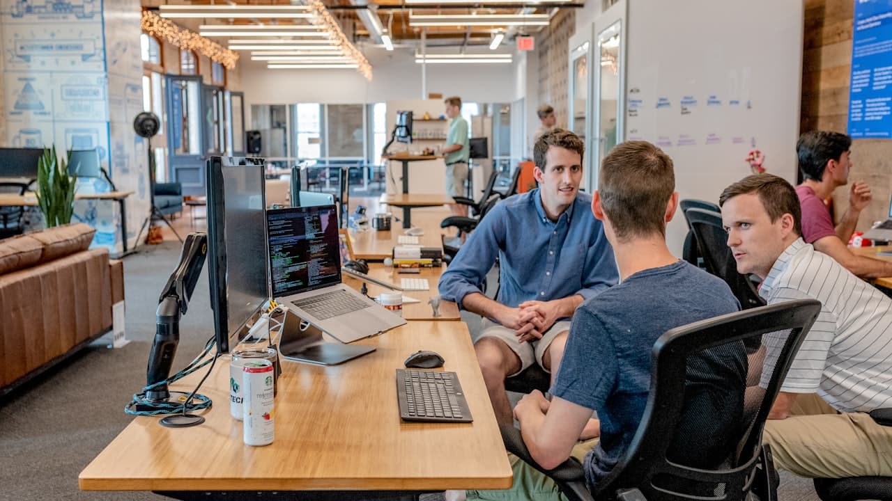 Three colleagues reviewing figures together at a desk in an office